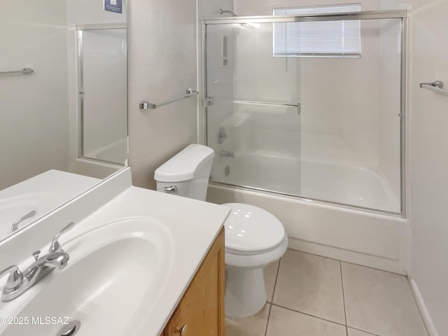 full bathroom with tile patterned flooring, bath / shower combo with glass door, vanity, and toilet