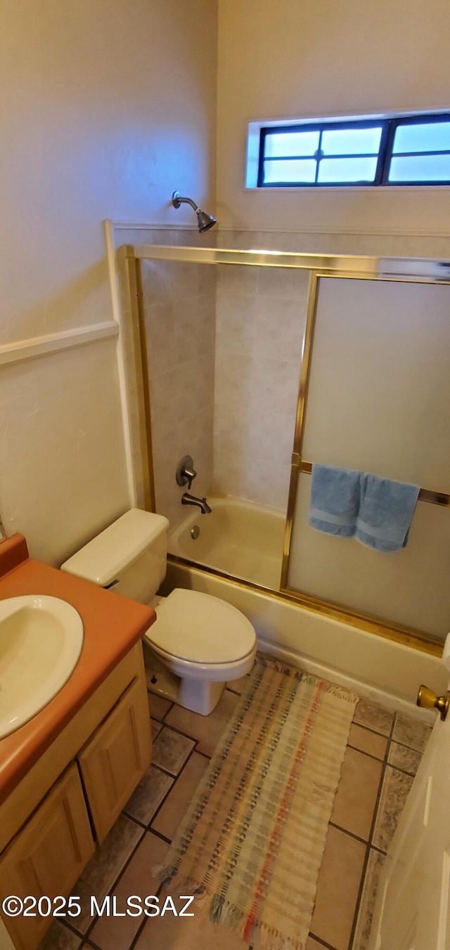 full bathroom with tile patterned flooring, enclosed tub / shower combo, vanity, and toilet