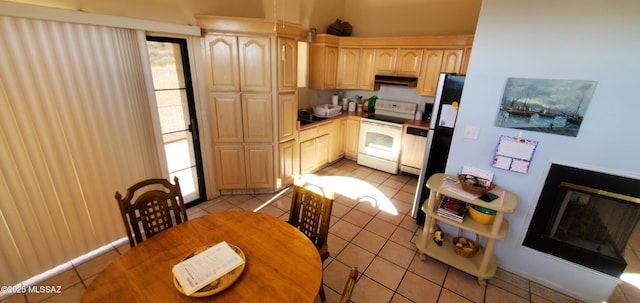 kitchen with electric stove, light tile patterned flooring, and light brown cabinets