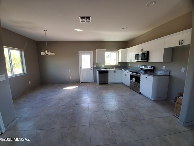 kitchen with white cabinetry, hanging light fixtures, a wealth of natural light, and stainless steel appliances