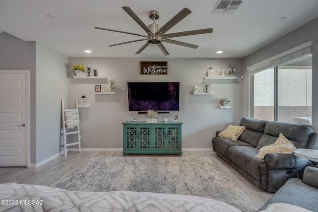 living room featuring ceiling fan and light hardwood / wood-style floors