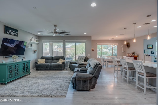 living room with ceiling fan and light hardwood / wood-style floors