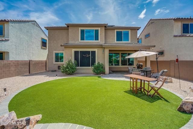 back of property featuring a yard and a patio area