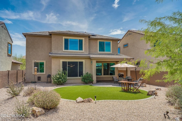 rear view of property with a lawn and a patio area