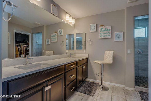 bathroom with vanity and tiled shower