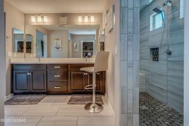 bathroom with vanity and a tile shower