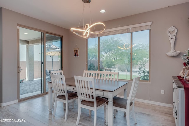 dining area featuring an inviting chandelier and light hardwood / wood-style floors