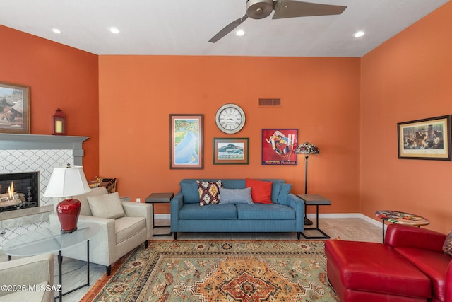 living room with a fireplace and ceiling fan