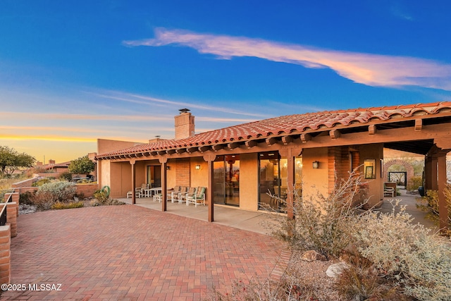 back house at dusk with a patio