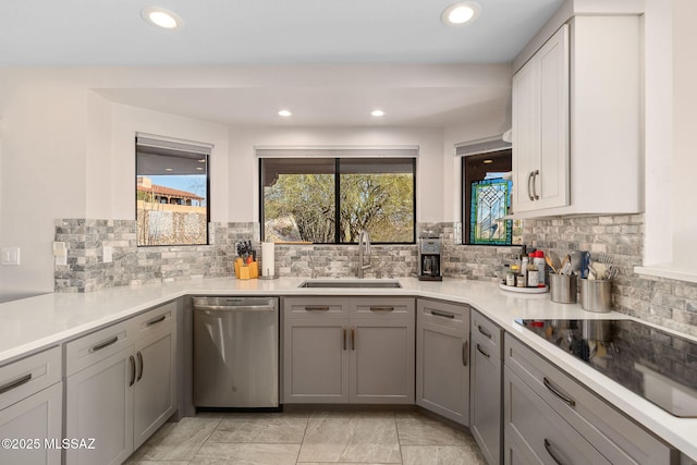 kitchen with sink, gray cabinetry, stainless steel dishwasher, black electric stovetop, and decorative backsplash