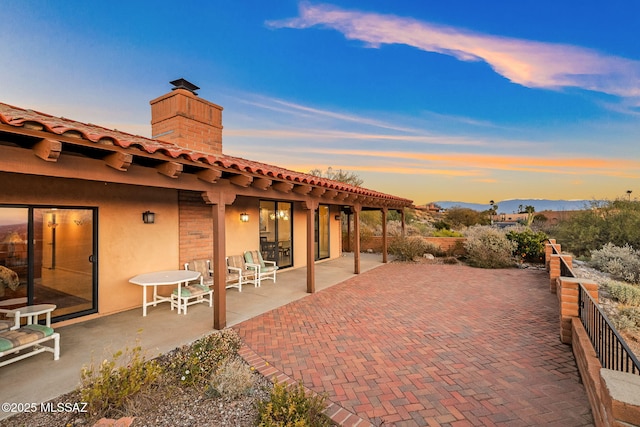 patio terrace at dusk featuring a mountain view