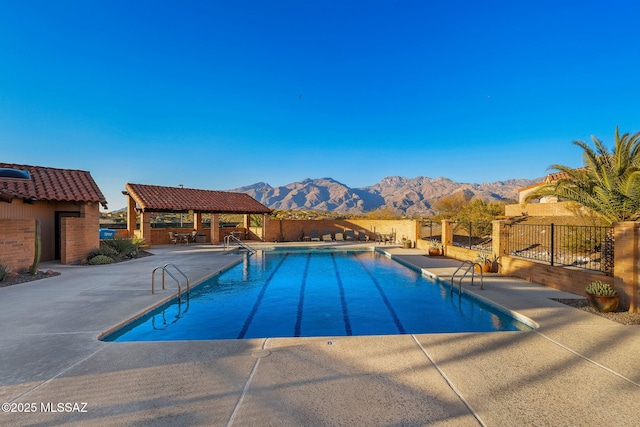 view of swimming pool with a gazebo, a mountain view, exterior bar, and a patio area