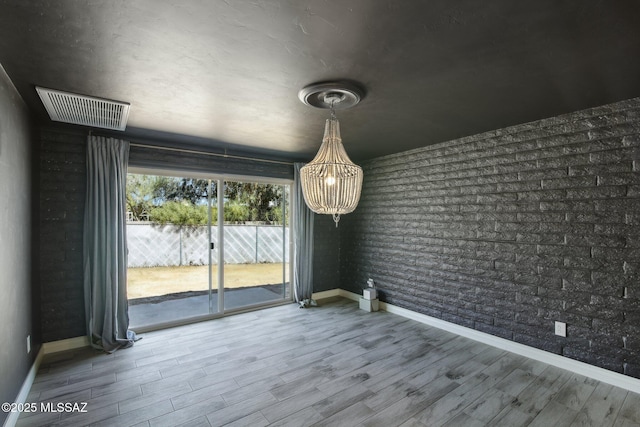 unfurnished dining area with visible vents, baseboards, and wood finished floors
