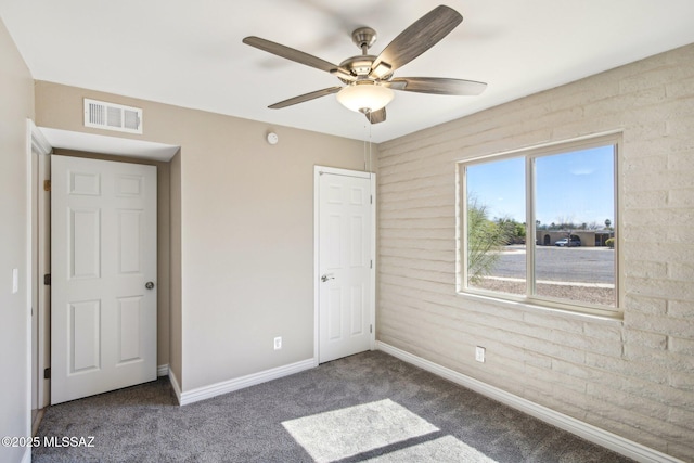 unfurnished bedroom with baseboards, carpet floors, visible vents, and a ceiling fan