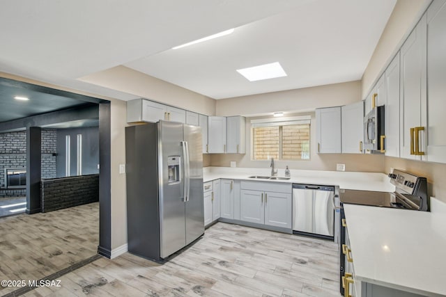 2572 W Calle Genova, Tucson, AZ 85745 - kitchen with appliances with stainless steel finishes, a sink, light wood-style floors, light countertops, and baseboards