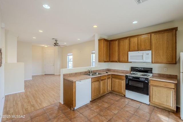 kitchen featuring sink, white appliances, light tile patterned floors, kitchen peninsula, and ceiling fan