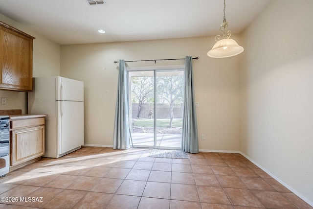 kitchen featuring white refrigerator, range, light tile patterned flooring, and pendant lighting