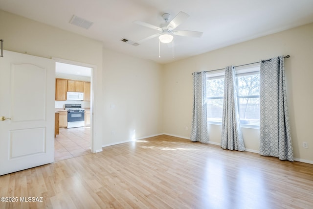 empty room with light hardwood / wood-style flooring and ceiling fan