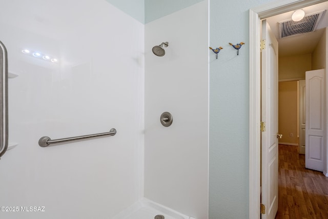 bathroom with hardwood / wood-style floors and walk in shower