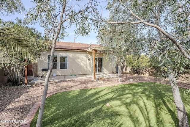 back of property featuring a patio area and a lawn