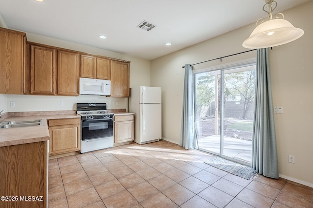 kitchen with sink, white appliances, hanging light fixtures, and light tile patterned flooring