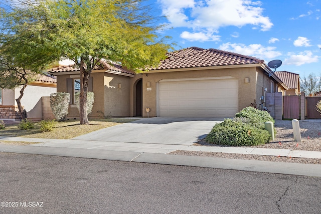 mediterranean / spanish-style house with a garage, a tile roof, fence, driveway, and stucco siding