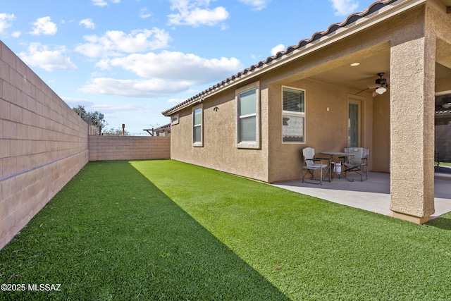 view of yard featuring a patio area, ceiling fan, and a fenced backyard