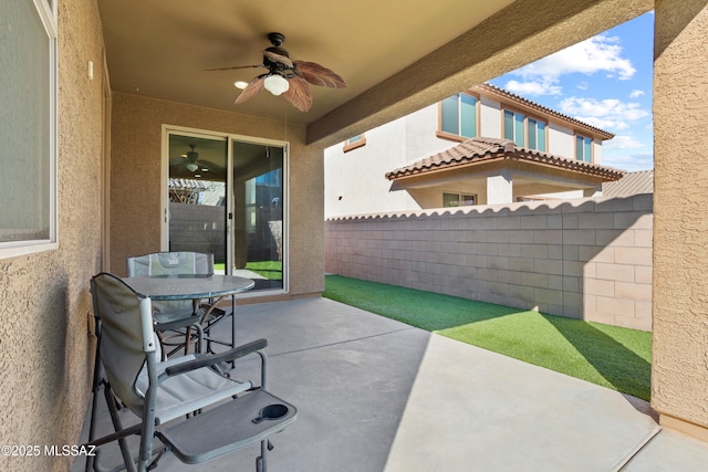 view of patio with fence and a ceiling fan