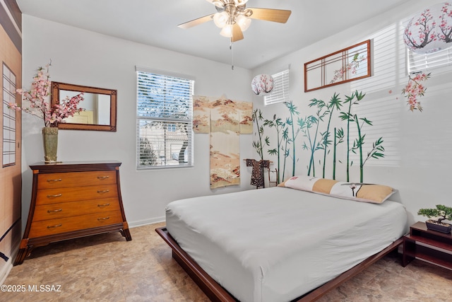 bedroom with ceiling fan and baseboards