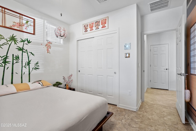 bedroom featuring a closet, visible vents, and baseboards