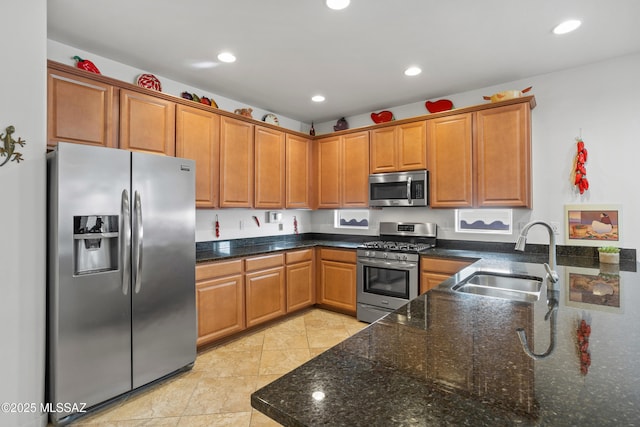 kitchen featuring appliances with stainless steel finishes, brown cabinetry, a sink, and recessed lighting