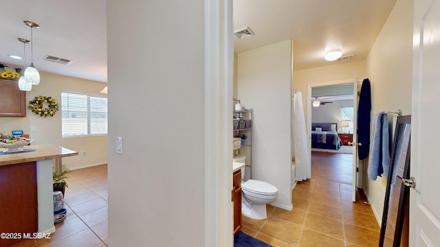 bathroom with tile patterned flooring, vanity, and toilet