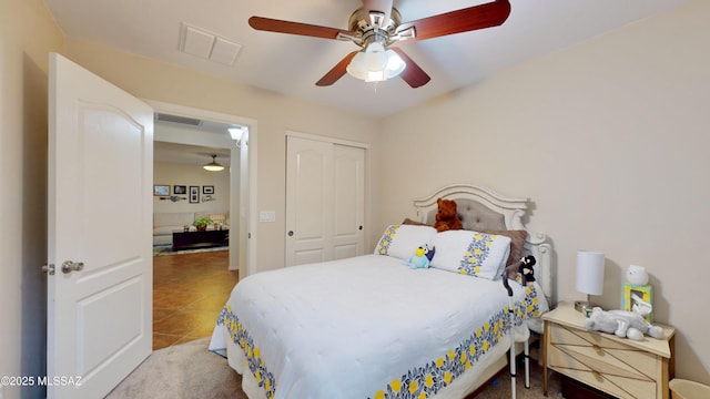 bedroom with tile patterned flooring, ceiling fan, and a closet