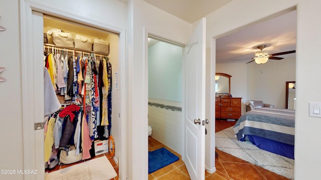 tiled bedroom with tile walls, a closet, and ceiling fan