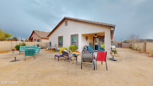 rear view of property with a patio area and ceiling fan