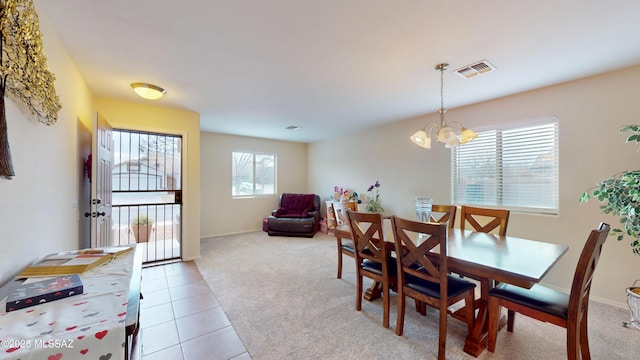 dining room featuring light carpet and an inviting chandelier