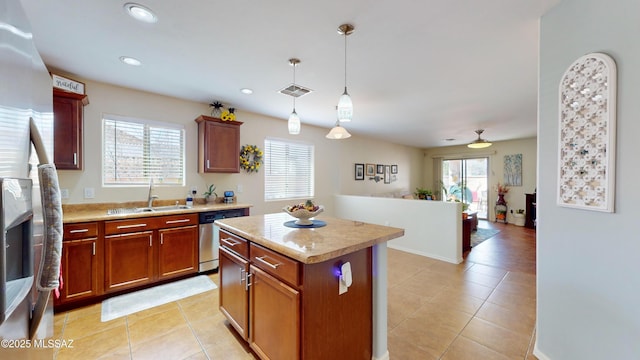 kitchen featuring appliances with stainless steel finishes, sink, hanging light fixtures, a center island, and a healthy amount of sunlight