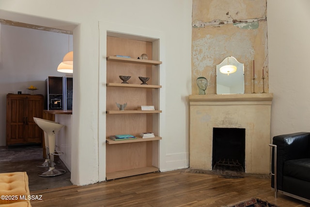 interior space featuring dark hardwood / wood-style floors, a high end fireplace, and built in shelves