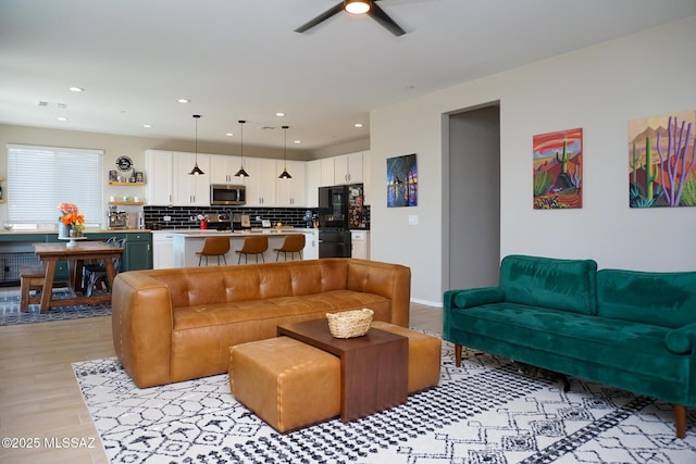 living room with ceiling fan and light wood-type flooring