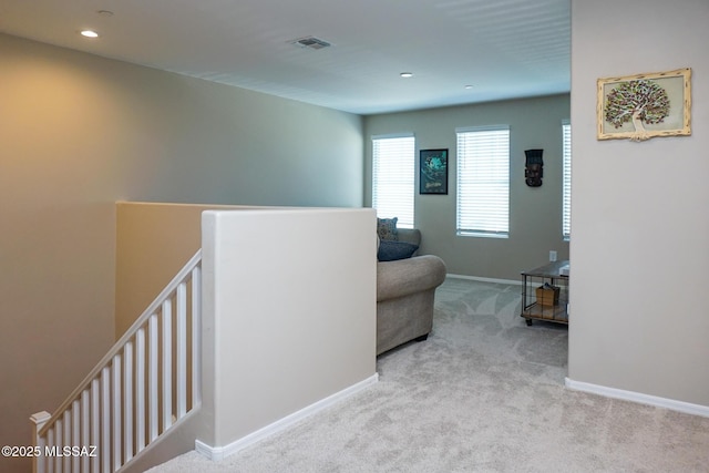 corridor featuring light colored carpet