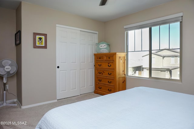 carpeted bedroom featuring ceiling fan and a closet