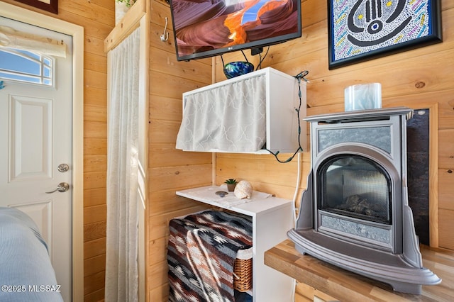 interior space featuring a wood stove and wooden walls