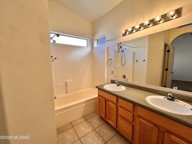 bathroom featuring tiled shower / bath combo, vanity, lofted ceiling, and tile patterned floors