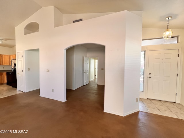 entrance foyer with high vaulted ceiling and carpet