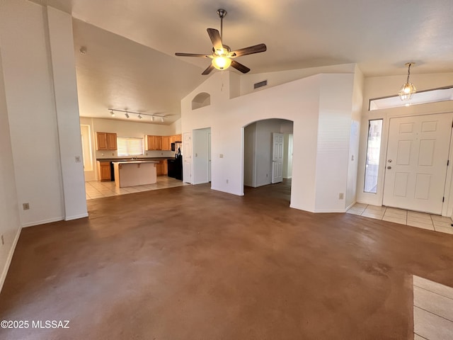 unfurnished living room featuring high vaulted ceiling, rail lighting, and ceiling fan