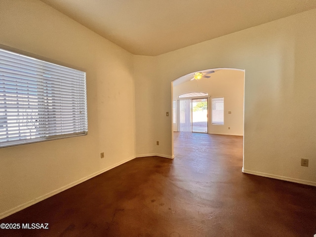 unfurnished room with ceiling fan and concrete floors