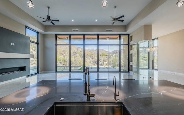 kitchen with open floor plan, visible vents, and a ceiling fan