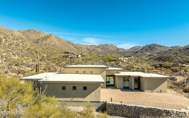 mid-century home featuring a mountain view and stucco siding