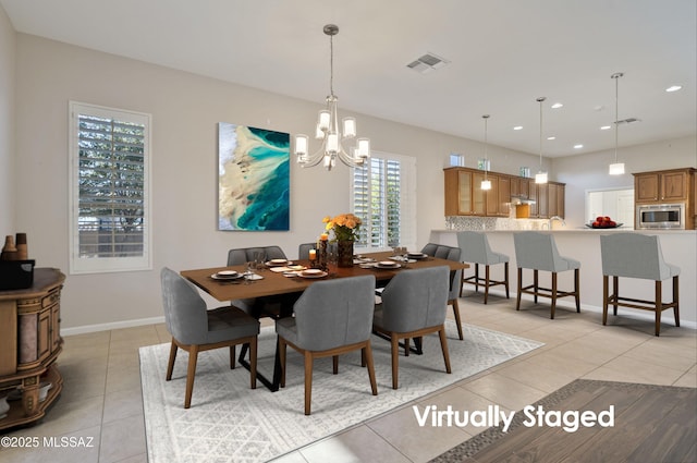 dining space featuring light tile patterned floors and a chandelier