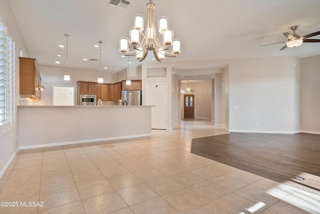 unfurnished living room featuring ceiling fan with notable chandelier and light tile patterned floors